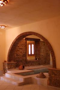 Habitación de piedra con arco en un edificio en La Molinilla Apartamentos y Hammam en Linares de la Sierra