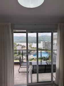 a living room with a table and chairs and a large window at Complejo Venetto Village in Villa Parque Siquiman +2 photos