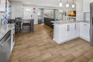 una cucina con mobili bianchi e pavimento in legno di Three bedroom family home with off street parking and fenced yard a Centennial