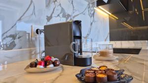 a coffee maker and a plate of cupcakes on a counter at Luxury apartment with panoramic sea view ruby in Alanya +89 photos