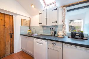 une cuisine avec des armoires blanches et un comptoir dans l'établissement Beach Cottage, à Haverfordwest