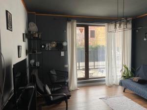 a living room with a chair and a window at INC apartment in villa in Bucharest
