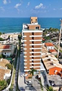 een hoog gebouw met de oceaan op de achtergrond bij Pedra do Sal Privilege in Salvador +2 foto's