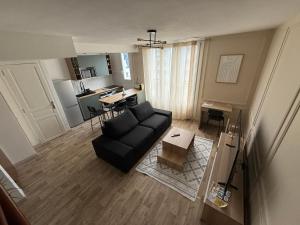 a living room with a couch and a table at Le Green -5p-2 rooms- Free parking -Clim mobile in Grenoble