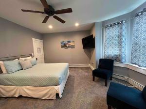 ein Schlafzimmer mit einem Bett, einem Deckenventilator und einem Stuhl in der Unterkunft Blue Anchor Estate-BEACH BLOCK in the Orange Loop in Atlantic City