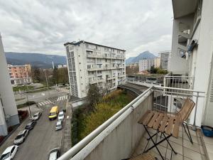 a balcony with a chair and a city street at Le Green -5p-2 rooms- Free parking -Clim mobile in Grenoble