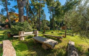 um parque com um banco de madeira na relva em Cozy Apartment In Sveti Filip I Jakov em Sveti Filip i Jakov