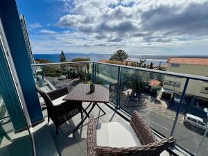 a balcony with a table and chairs and the ocean at Welcome to Paradise Island in Caniço