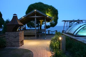 a gazebo next to the ocean at night at Apartamentai Roma in Neringa