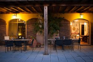 a patio with tables and chairs in a building at Fattoria San Paolo Agriturismo in Montecastelli