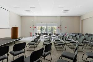 an empty room with chairs and a podium at Lofts Marambaia in Petrópolis +25 photos