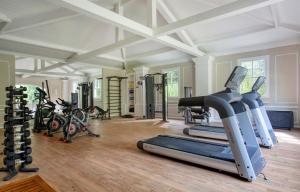 a gym with several treadmills and exercise bikes at Lofts Marambaia in Petrópolis