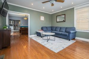 Una sala de estar con un sofá azul y una mesa. en Large 2 story home with fenced back yard, en Indianápolis