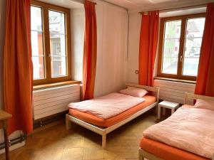 a bedroom with two beds and two windows at Maison La Coquille in La Chaux-de-Fonds +6 photos