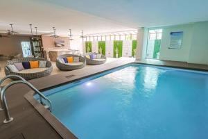 サントドミンゴにあるElegant Centric Apt Near allの大きなスイミングプール(椅子、テーブル付)