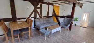 a living room with a couch and a table and chairs at Ferienwohnung nähe Marburg und Gießen in Fronhausen