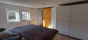 a bedroom with a bed and a closet and two windows at Ferienwohnung nähe Marburg und Gießen in Fronhausen +6 photos