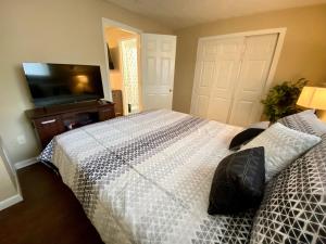 a bedroom with a bed and a flat screen tv at Like Home at Fairmont in Lexington