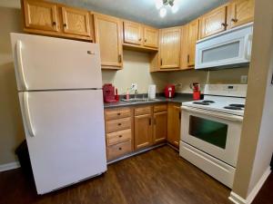 a kitchen with a white refrigerator and wooden cabinets at Like Home at Fairmont in Lexington