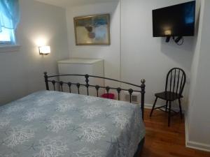 ein Schlafzimmer mit einem Bett und einem Flachbildfernseher in der Unterkunft Ocean Block Beach Badges Cute Cottage In The Oceanblock No Streets To Cross 7 Houses To The Ocean Rear Cottage 13048 in Surf City