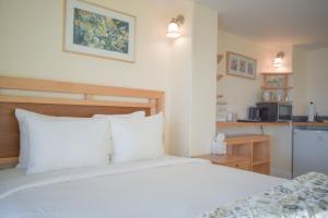 een slaapkamer met een wit bed en een keuken bij Lakeshore Lodging Lodge 613 in Homer