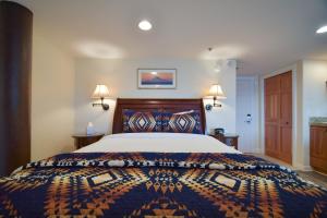 a bedroom with a large bed and two lamps at Lakeshore Lodging Lodge 615 in Homer