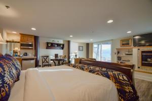 a bedroom with a large bed and a kitchen at Lakeshore Lodging Lodge 615 in Homer