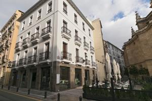 a white building on the side of a street at Siloe Plaza in Granada