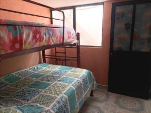 a bedroom with a bunk bed and a window at La Casa de los Abuelos in Zacatlán