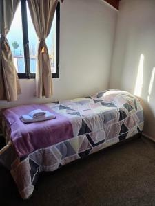 a bedroom with a bed in a room with a window at Miniloft Centrico in El Calafate +5 photos