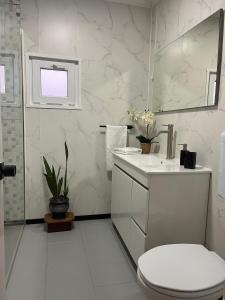 a white bathroom with a toilet and a sink at A Casa dos Avós in Lajes das Flores