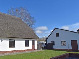 a white house with a roof and a yard at Ferien unterm Reetdach bis zu 6 Personen in Alt Bukow