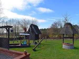 a playground with a slide and a swing set at Ferien unterm Reetdach bis zu 6 Personen in Alt Bukow