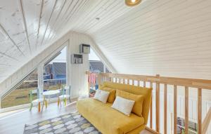 a living room with a yellow couch and a staircase at 2 Bedroom Nice Home In Zerpenschleuse in Zerpenschleuse