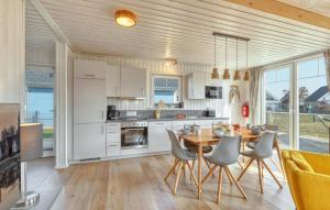 a kitchen with white cabinets and a table and chairs at 2 Bedroom Nice Home In Zerpenschleuse in Zerpenschleuse