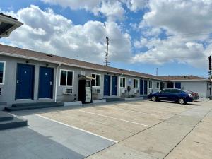 a car parked in front of a building with blue doors at vogue motel in South Gate