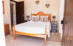 a bedroom with a large bed with white sheets at Casa Bellarosa in Raposeira