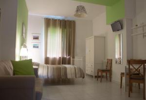 レッチェにあるB&B Le Comari Salentineのベッドルーム1室(ベッド1台、ソファ、椅子付)