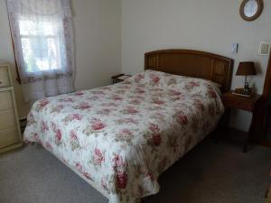 um quarto com uma cama com uma colcha floral em Wifi, Deck,yard, Ocean Side Duplex 2Nd Floor In Ship Bottom 10609 em Ship Bottom