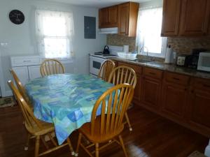 uma cozinha com uma mesa com cadeiras e um fogão em Wifi, Deck,yard, Ocean Side Duplex 2Nd Floor In Ship Bottom 10609 em Ship Bottom