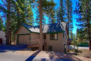 a house with a garage in the woods at Gale Force Wind home in Incline Village