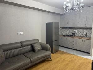 a living room with a couch and a kitchen at monolit residens 6C blok in Tbilisi City +11 photos