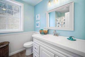 a bathroom with a toilet and a sink and a mirror at The Sand Star-4BDRM Ventnor Home near Bay & AC in Ventnor City +46 photos