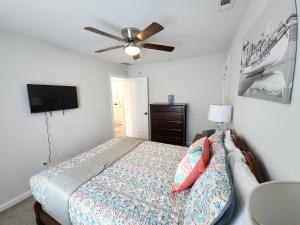 a bedroom with a bed and a ceiling fan at The Sand Star-4BDRM Ventnor Home near Bay & AC in Ventnor City