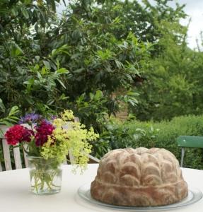 a cake on a table next to a vase of flowers at Atelierhaus in Rehborn +20 photos
