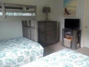 een slaapkamer met een stapelbed en een televisie bij Ocean Side Home In Ship Bottom Beach Badges Pool Wifi 92468 in Ship Bottom +11 foto's