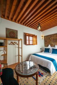 a bedroom with a bed and a table at Riad Fes la Mama - Rooftop in Fez
