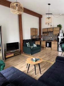 a living room with a couch and a table at Dawna Mleczarnia Apartamenty MIODOWY in Nowa Ruda