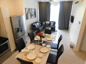 Un comedor con mesa y sillas y una sala de estar. en Sunset 205, sleeps six, next door to the pool, 100m to the beach!, en Jacó