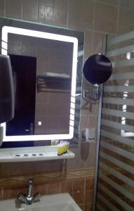 a bathroom with a mirror and a sink and a sink at فندق شموخ الماسة الفندقية in Az Zahrāʼ
